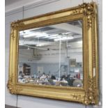 A Victorian Gilt and Gesso Framed Mirror, gadrooned, with scrollwork spandrels and mercury plate,