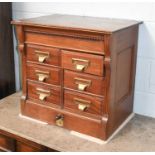 A Carved Mahogany Index Cabinet, circa 1920, maker Shannon, with a bank of six drawers and central