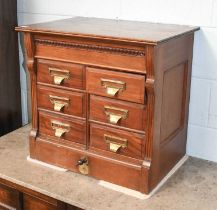 A Carved Mahogany Index Cabinet, circa 1920, maker Shannon, with a bank of six drawers and central