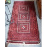 Baluch Rug, the field comprised of three panels each containing a hooked gül enclosed by multiple
