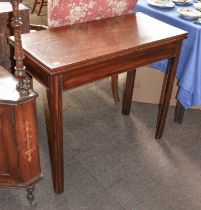 A George III Mahogany Fold Over Table, 86cm by 39cm by 73cm; together with two brass standard lamps,