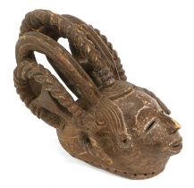 An Igbo Carved Wood Maiden Mask, Nigeria, the small oval face with pierced slit eyes, long