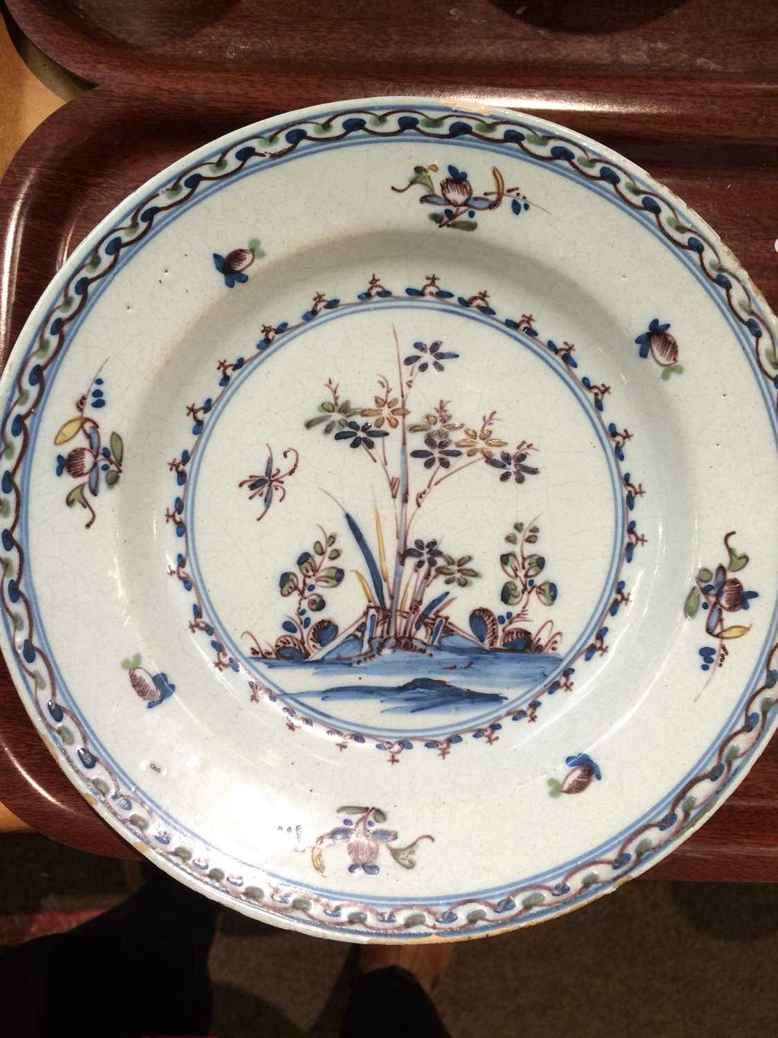 An English Delft Plate, 18th century, painted with a roundel landscape in blue, green, manganese and - Image 7 of 9