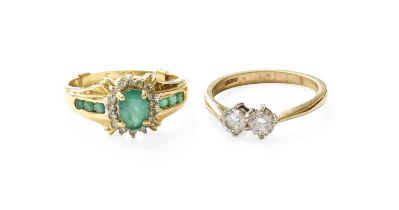 A 14 Carat Gold Emerald and Diamond Cluster Ring, the oval cut emerald within a border of round