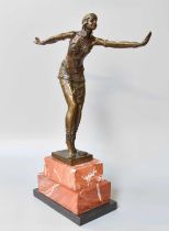 After Dimitri Chiparus: an Art Deco style bronzed metal sculpture of a dancing lady, raised on red