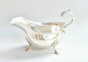 An Edward VII Silver Sauceboat, by Walker and Hall, Sheffield, 1907, oval and on three shell-