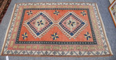 Turkish Rug, the faded terracotta field with two latch hook medallions enclosed by borders of