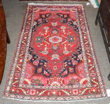 Hamadan Rug, the crimson field of stylised flowers framed by spandrels and angular vine borders,