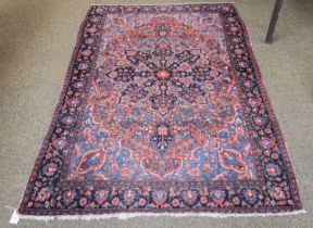 Hamadan Rug, the madder field richly decorated with flowers centred by an indigo medallion, framed