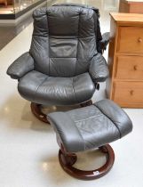 A Grey Leather Stressless Reclining Chair and Matching Stool In good condition, wear to the