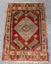 Turkish Yastik Rug, the deep blood red field centred by a stepped medallion with spandrels of