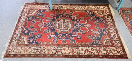 Tafrish Rug, the blood red field with central medallion enclosed by ivory borders, 198cm by 131cm