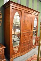 An Edwardian Inlaid Mahogany Wardrobe, the central cupboard above four drawers flanked by twin