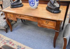 A French Walnut Bureau Plat, with cleated plank top, with three drawers over square scrolled