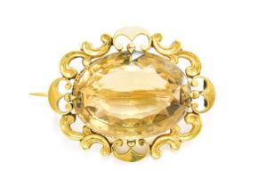 A Smoky Quartz Brooch, the oval cut smoky quartz in a four claw setting within a yellow scroll