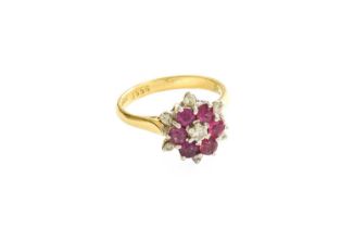 An 18 Carat Gold Ruby and Diamond Cluster Ring, the central round brilliant cut diamond within a