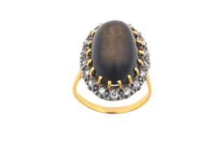 A Cat's-Eye Stone and Diamond Cluster Ring the oval cabochon cat's-eye stone in a yellow claw