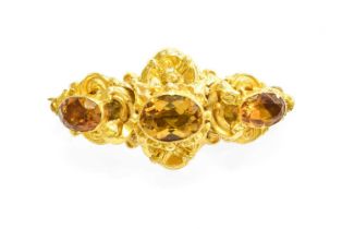 A Citrine Brooch, the graduated oval cut citrines within a yellow foliate design frame, measures 4.