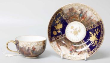 A 20th Century Meissen Tea Cup and Saucer, painted with panels of fishing scenes In good