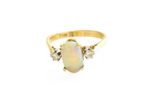 An Opal and Diamond Three Stone Ring, the oval cabochon opal in a yellow claw setting, flanked by