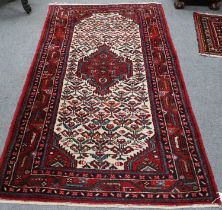 Hamadan Rug, the ivory field of geometric plants centred by a deep raspberry medallion enclosed by