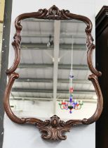 A Carved Mahogany Framed Mirror, decorated with scrolls, 53cm by 75cm