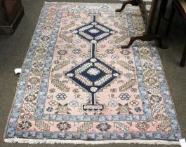 Heriz Rug, North West Iran, the faded rose pink field with two stepped indigo medallions enclosed by