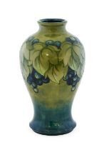 William Moorcroft (1872-1945): A Leaf and Berry Pattern Baluster Vase, on a celadon teal ground,