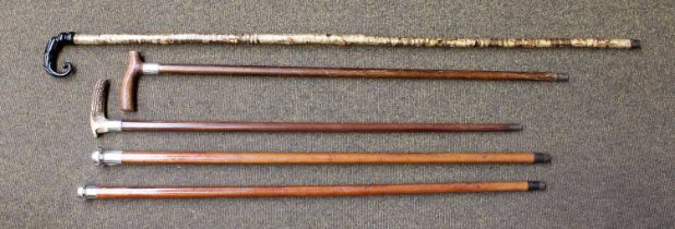 Five Walking Sticks/Canes, including malaca examples with silver toppers and a antler handled