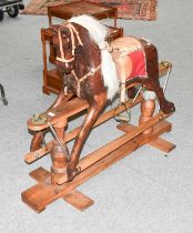 A Wooden Rocking Horse, with leather tack on a trestle base, 100cm high by 120cm