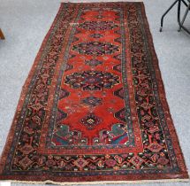Azeri Long Rug, the rich terracotta field with three flowerhead medallions enclosed by charcoal