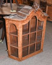 A Reproduction Burr Walnut Hanging Display Cupboard, with carved arch top pediment and having