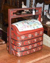 A Chinese Red Lacquered Tiered Food Carrier, the top section set with a painted porcelain panel,