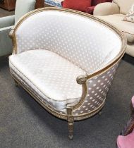 A Louis XV Style Carved Giltwood Two Seater Settee, with silk upholstery and on reeded tapering