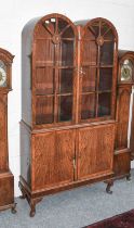 A Reproduction Crossbanded and Checked String Inlaid Walnut Cabinet, with twin arched glazed doors