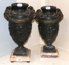 A Pair of Neoclassical Bronzed Vases, twin ram's head handles, putti relief friezes, on marble