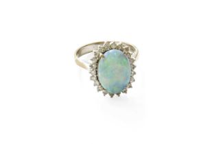 An 14 Carat White Gold Opal and Diamond Cluster Ring, the oval cabochon opal within a border of