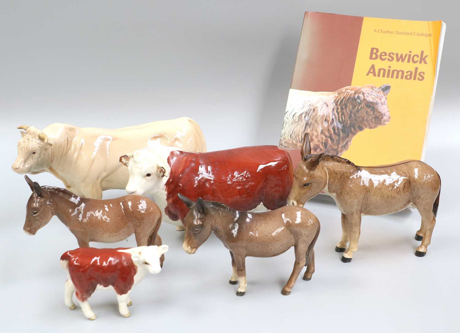 A Beswick Hereford Bull and Calf, together with a Chardais Bull, Three Donkeys and a 5th Edition