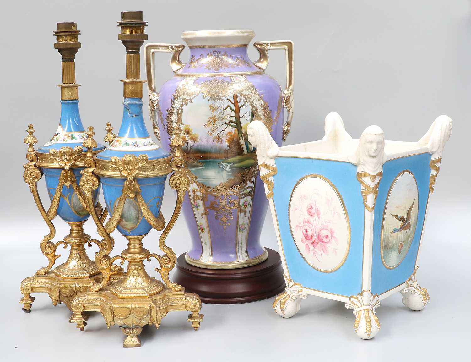 A Pair of Sèvres Style Porcelain Urns, late 19th / early 20th century, (a/f) with gilt metal