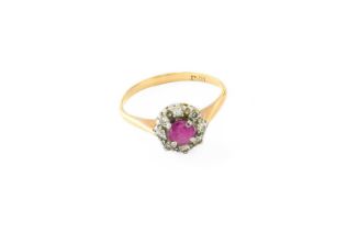 A Ruby and Diamond Cluster Ring, the round cut ruby within a border of eight-cut diamonds, in