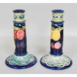 An Unusual Pair of William Moorcroft "Wisteria" Pattern Candlesticks, with twisted rope borders,