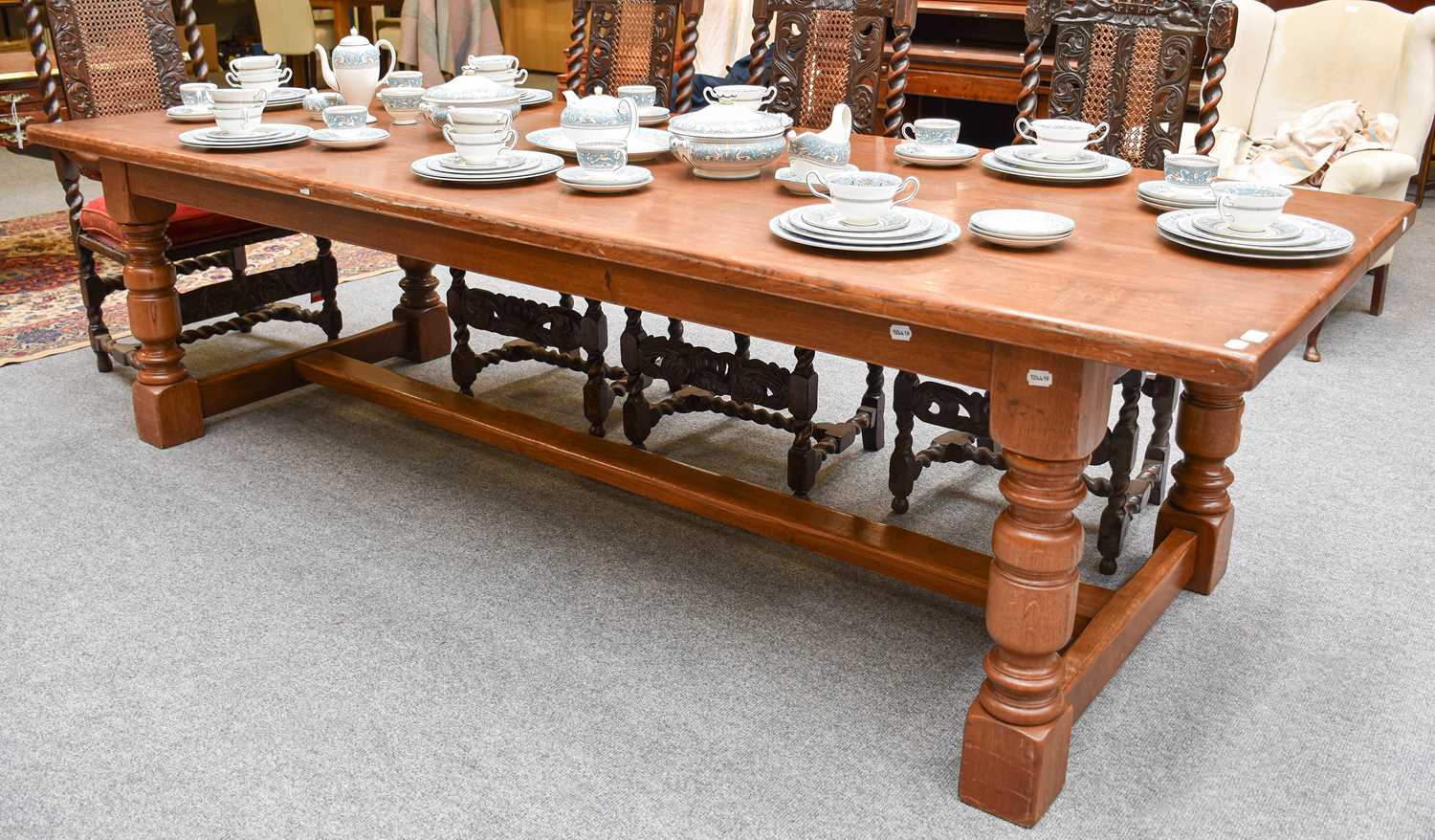 A Large Oak Vintage Refectory Table, the plank top raised on heavy turned supports to H stretcher,