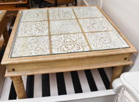 An Oka Mango Wood Coffee Table of square form, glazed carved floral top, turned legs, 46cm by 87cm