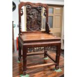 A Late 19th Century Chinese Heavily Carved Hardwood Chair, with stylised figural splat, solid