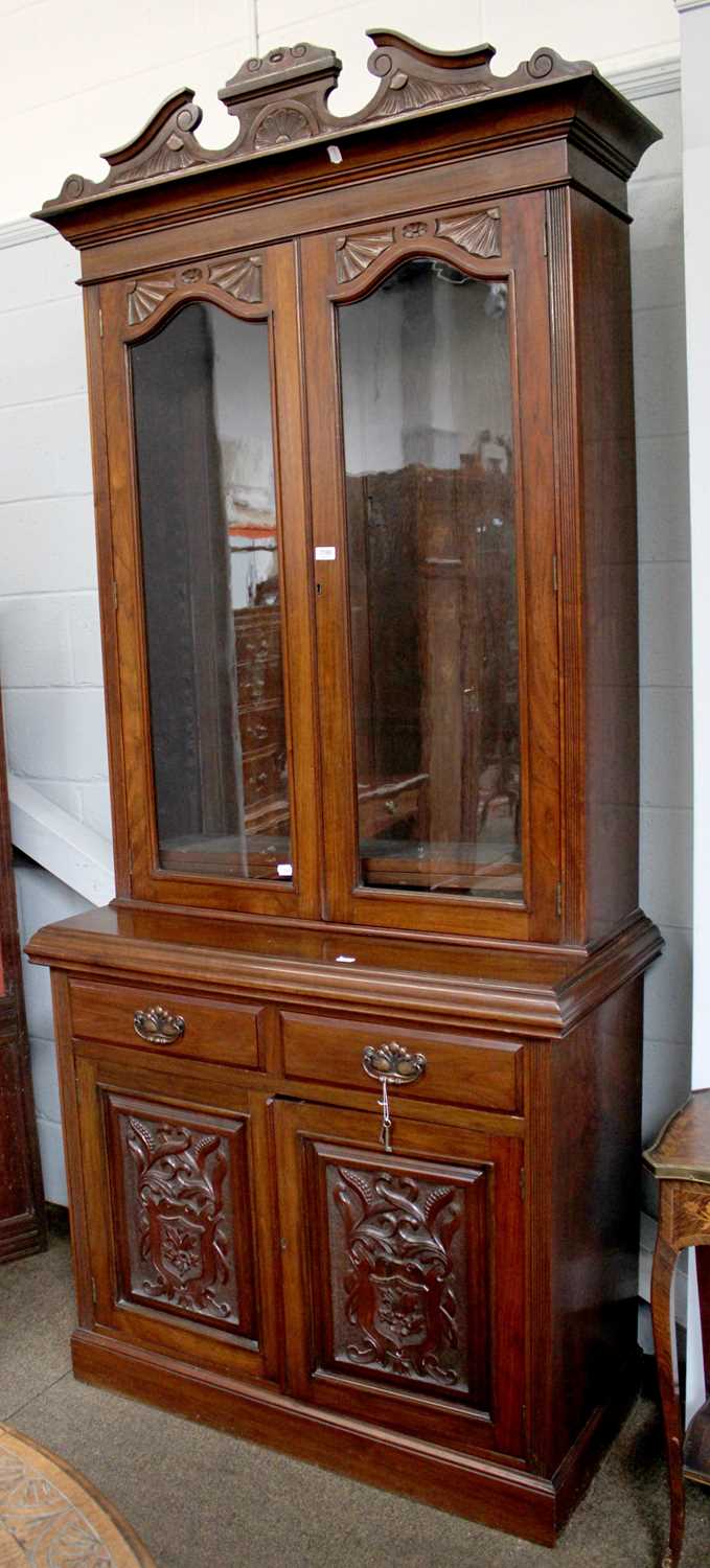 A Late Victorian Walnut Glazed Bookcase, broken pediment to cornice, twin glazed doors below, with