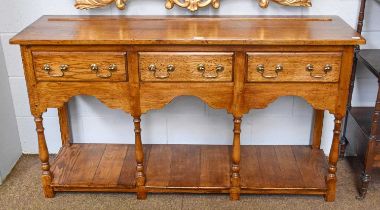 An 18th century Style Oak Low Dresser Base, three drawers, shaped aprons and turned column supports,