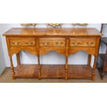 An 18th century Style Oak Low Dresser Base, three drawers, shaped aprons and turned column supports,