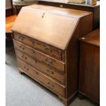 A George III Oak and Mahogany Crossbanded Bureau, the fall flap opening to reveal fitted interior,