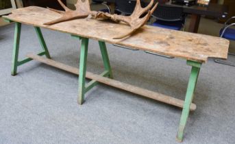 A 19th Century Pine Plank Top Trestle Table, on painted green legs, 75cm by 247cm by 57cm The