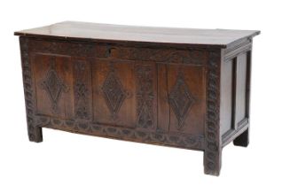 An late 17th/Early 18th century Oak Coffer, hinged lid, panelled front and sides, carved scroll